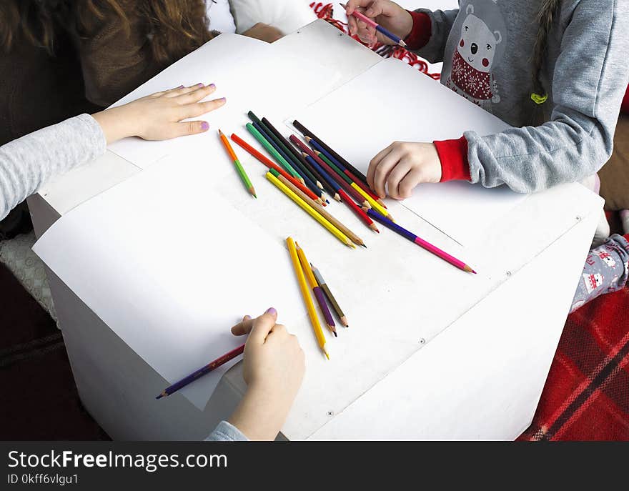 Children paint with colored pencils on white album sheets. Children paint with colored pencils on white album sheets