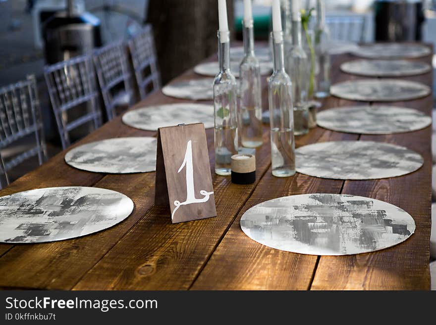 Table with food and flowers on the wedding. Number 1 written on white card stands before the bouquet in the center of dinner table.