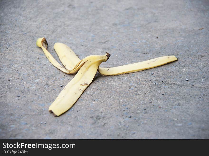 Banana peel was left on the concrete floor. The danger may slip. If anyone walks on it.