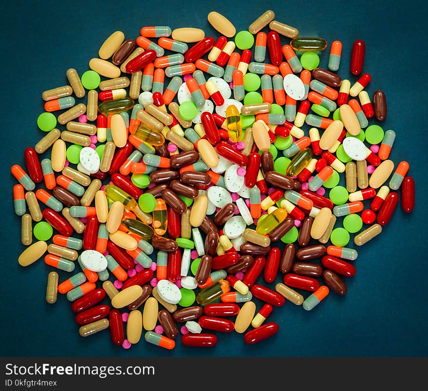 Pile of colorful tablets and capsules pills on blue background. Antibiotic resistance and drug use with reasonable concept. Pharmaceutical industry. Global healthcare. Drug interactions concept