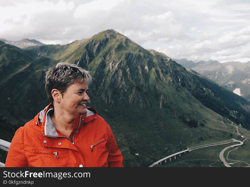 Person Wearing Windbreaker Jacket Standing Near on Mountain Range