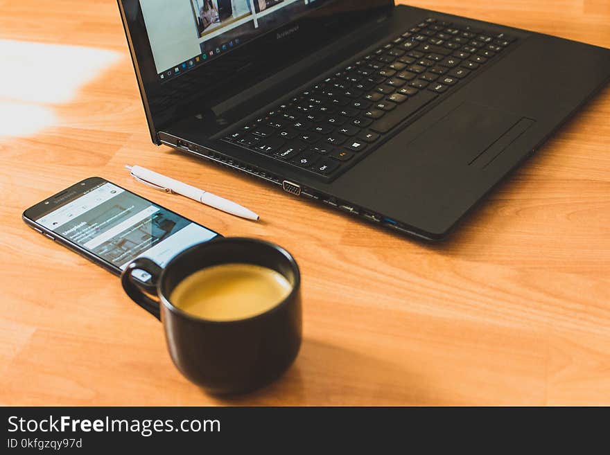 Black Laptop Computer and Black Ceramic Tea Cup