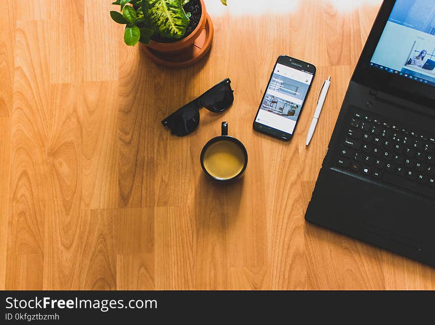 Black Laptop on Brown Table