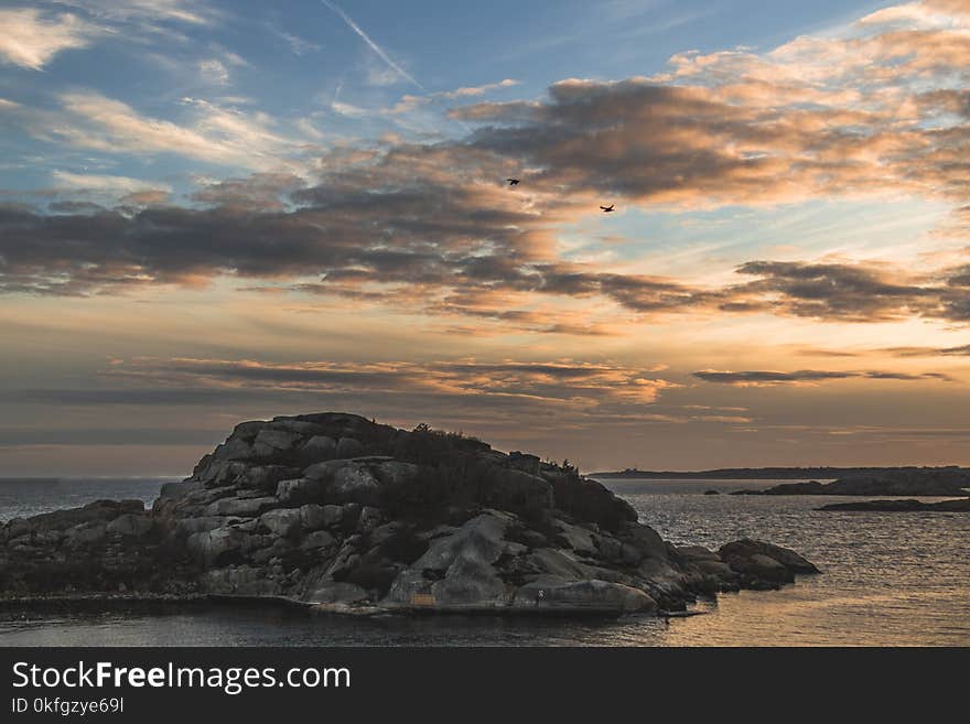 Island Surrounded by the Sea Under Stratus Clouds