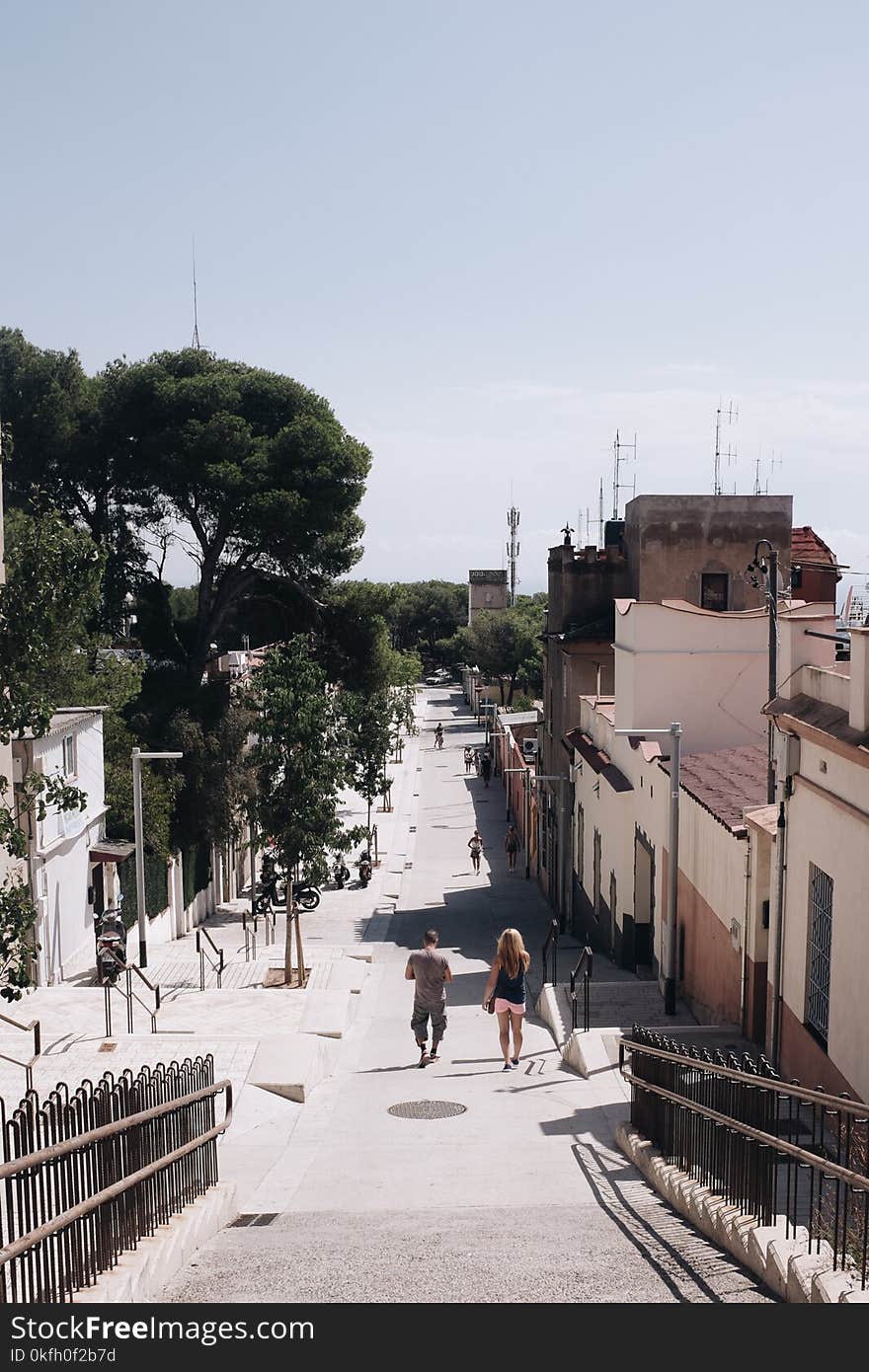 Man and Woman Walking on Gray Road