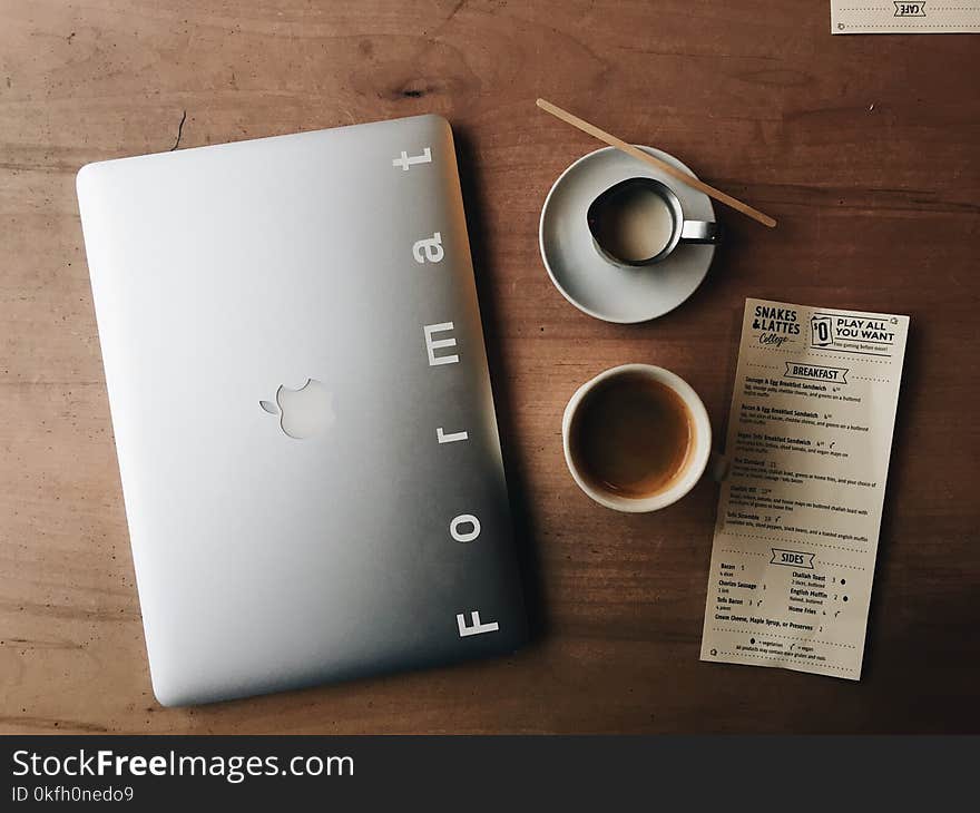 Photo of Macbook Near Cup and Saucer