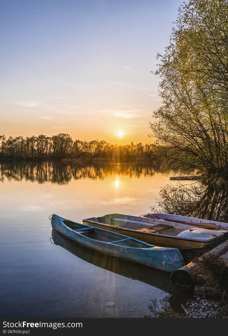 Three Brown Canoes Under Golden Hour