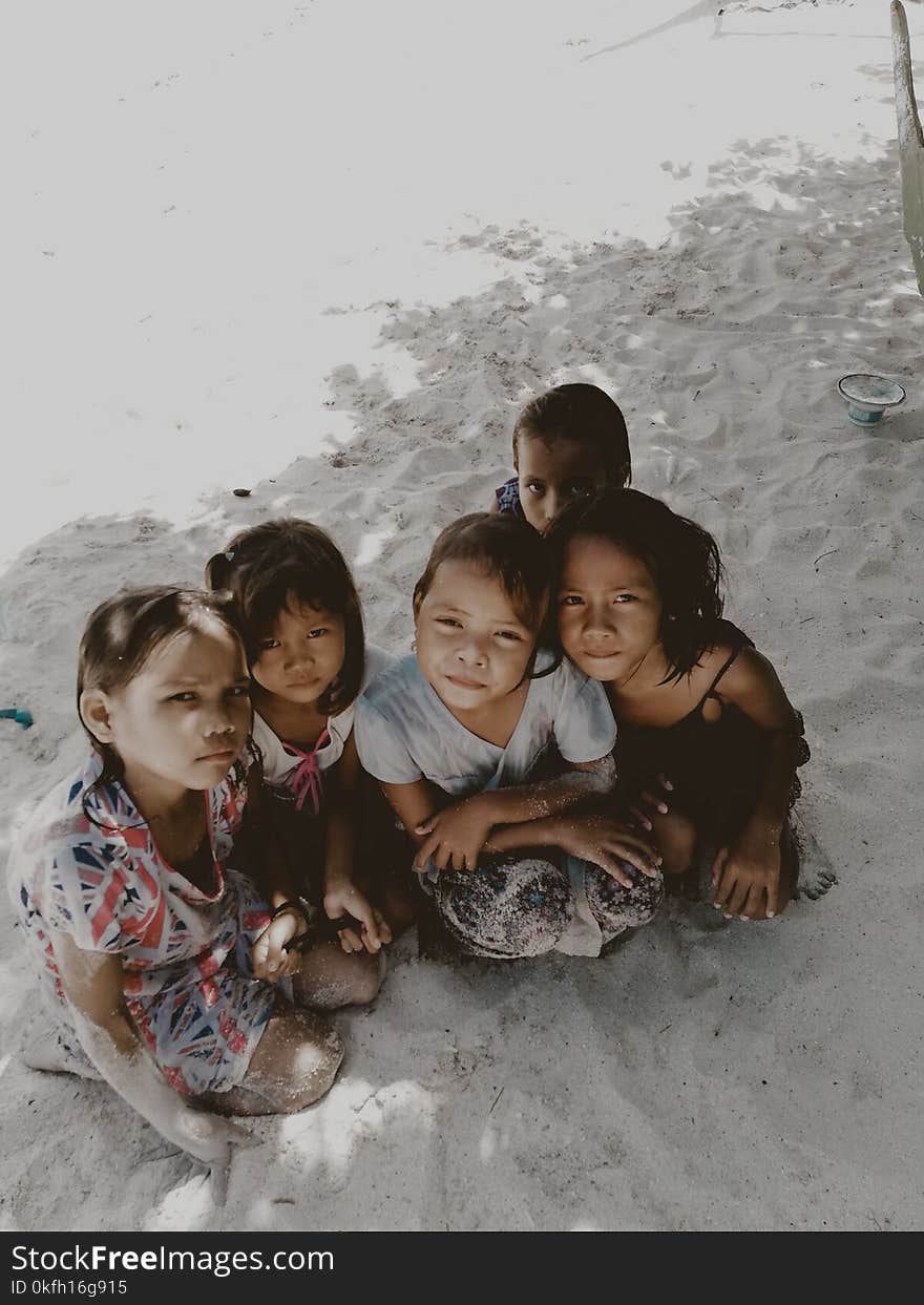 Five Toddlers Sitting on Sand