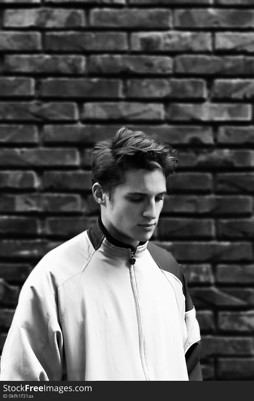 Man Wearing Zip-up Jacket With Brick Wall Background