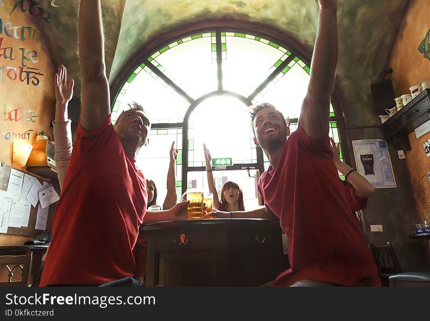 Group of people celebrating in a pub drinking beer and eating snacks