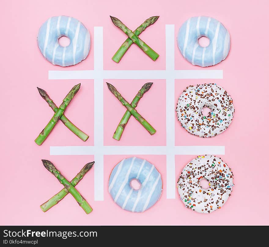 Tik tak toe game with donuts and asparagus. Health nutrition concept image