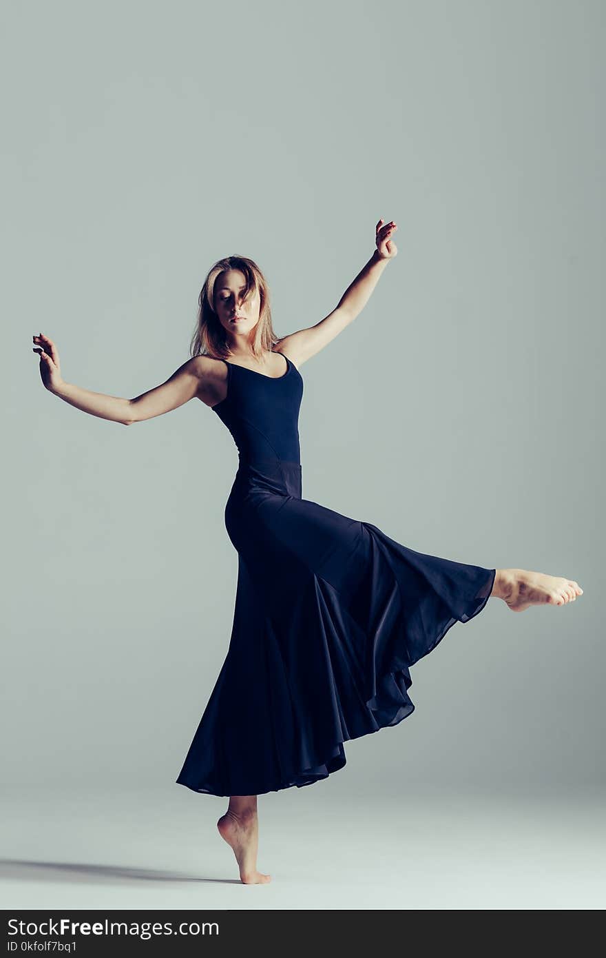 Young beautiful ballerina is posing in studio