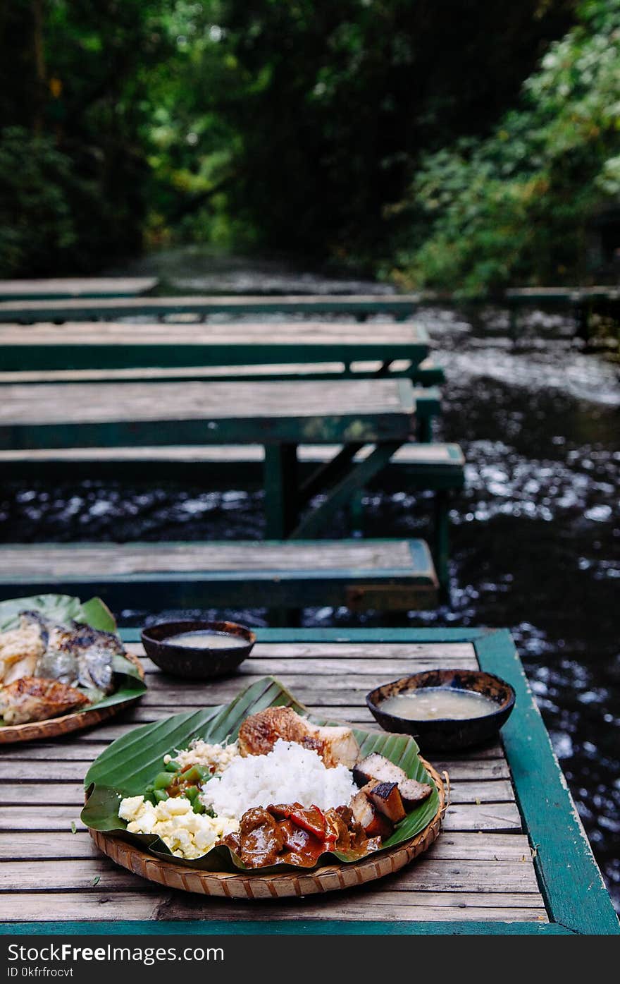 Meal set of various traditional Filippino Food, Pakbet on banana leaves and wooden table, side view. Meal set of various traditional Filippino Food, Pakbet on banana leaves and wooden table, side view