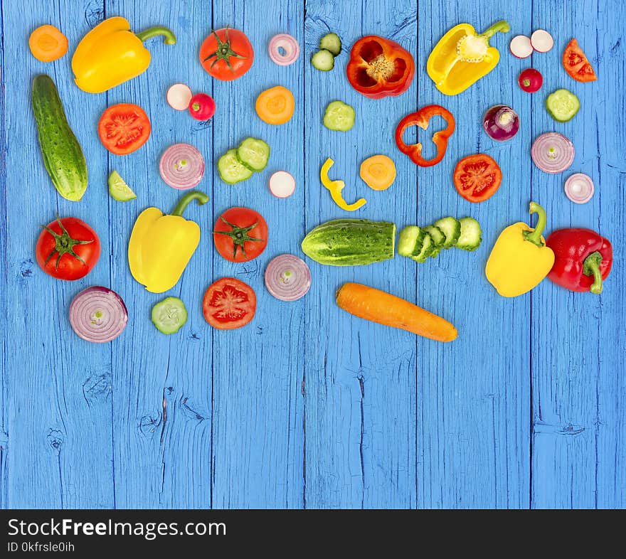 Vegetable Mix On Blue Wooden Ibackground. Fresh Yellow Pepper, Chopped Tomatoes, Onion, Round Cucumber Slice, Carrot, Radish.