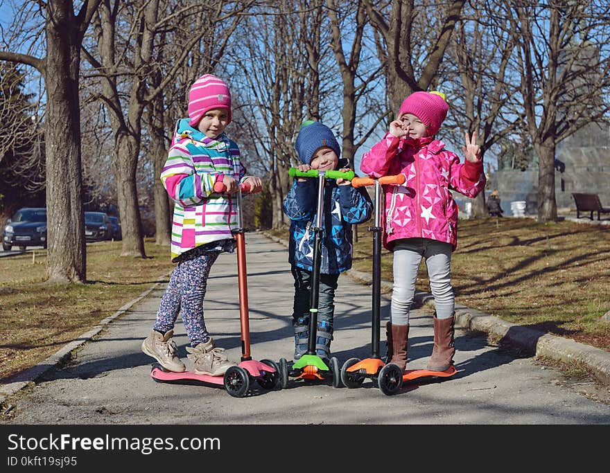 Treee children on the scooters in the park