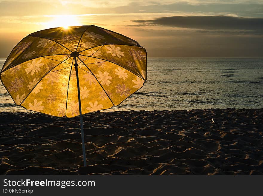 Beach umbrella on the beach in the evening sun