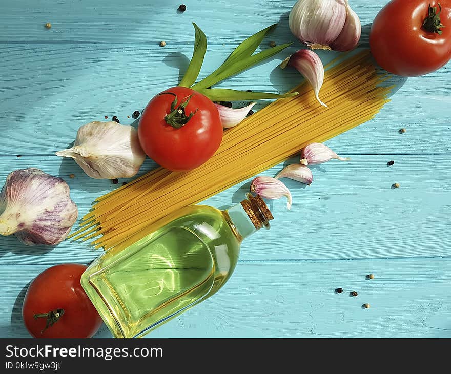 Spaghetti dried tomato garlic, pepper, oil on a blue wooden background