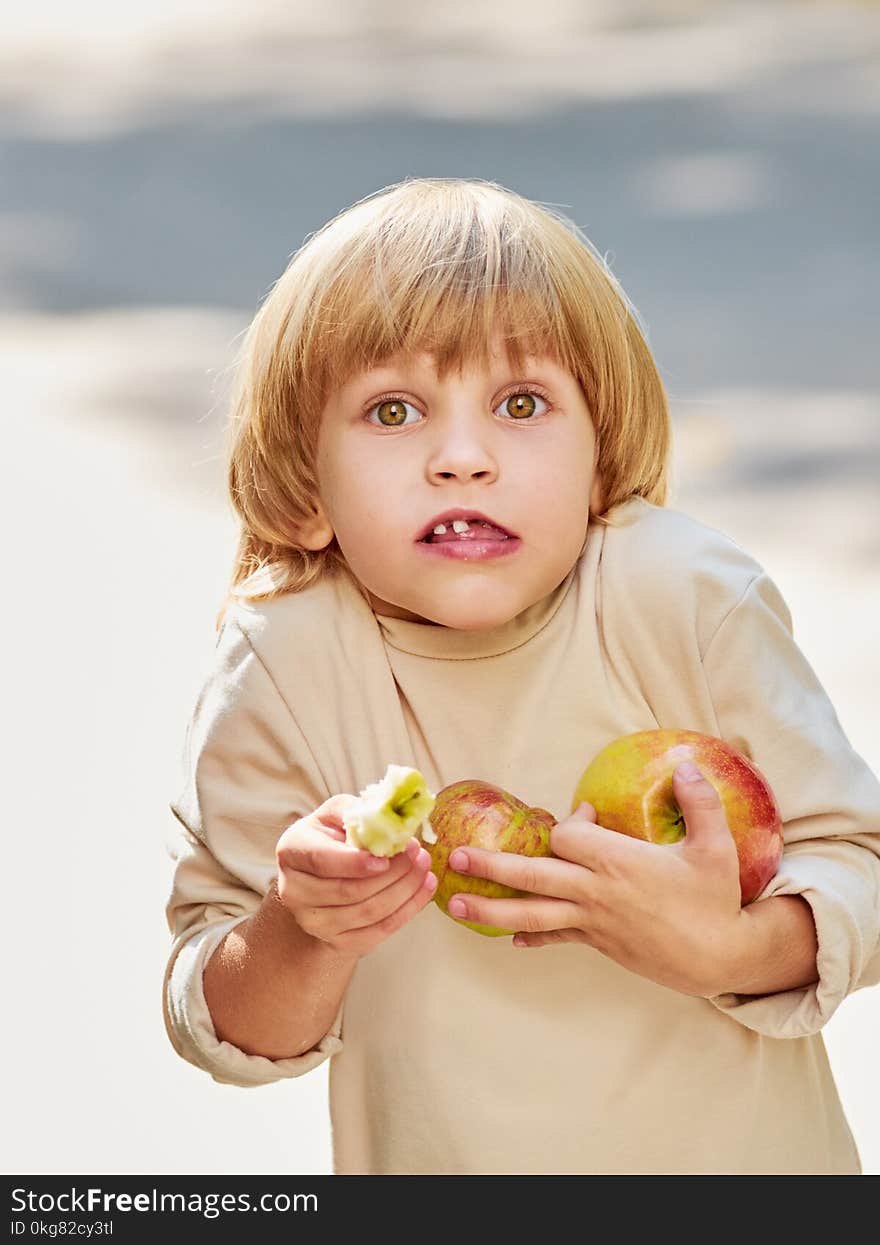 Portrait of funny little kid with milk teeth holding apples in hands. Portrait of funny little kid with milk teeth holding apples in hands