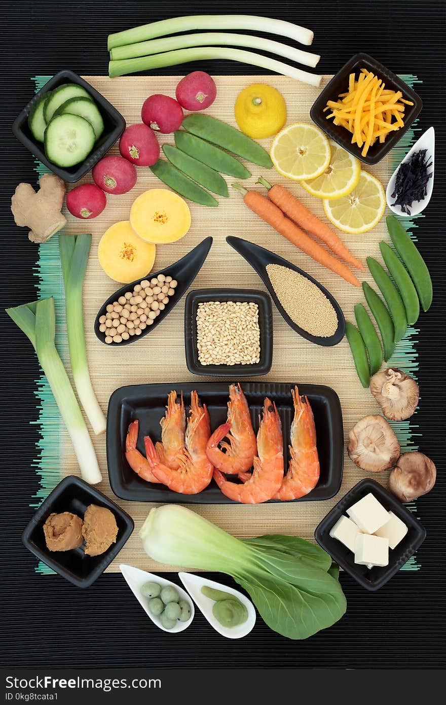 Macrobiotic diet food with seafood, wasabi paste and nuts, tofu, miso, legumes, seaweed, grains, fruit and vegetables with foods high in protein, fiber, antioxidants, minerals and vitamins. On bamboo background, top view. Macrobiotic diet food with seafood, wasabi paste and nuts, tofu, miso, legumes, seaweed, grains, fruit and vegetables with foods high in protein, fiber, antioxidants, minerals and vitamins. On bamboo background, top view.