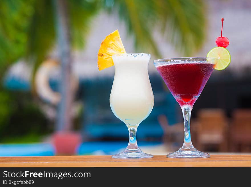 Two glasses of fruit cocktail by the beach