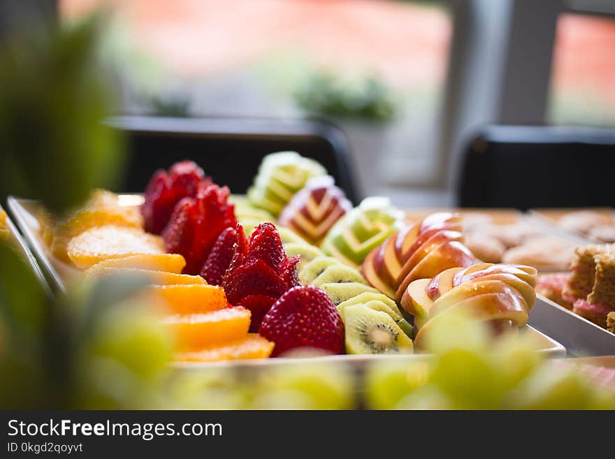 Neatly laid out delicious delicacies low-calorie desserts of sliced apples strawberry kiwi oranges and baked cookies are ready for any festive table during the any momentous event or holiday. Neatly laid out delicious delicacies low-calorie desserts of sliced apples strawberry kiwi oranges and baked cookies are ready for any festive table during the any momentous event or holiday.