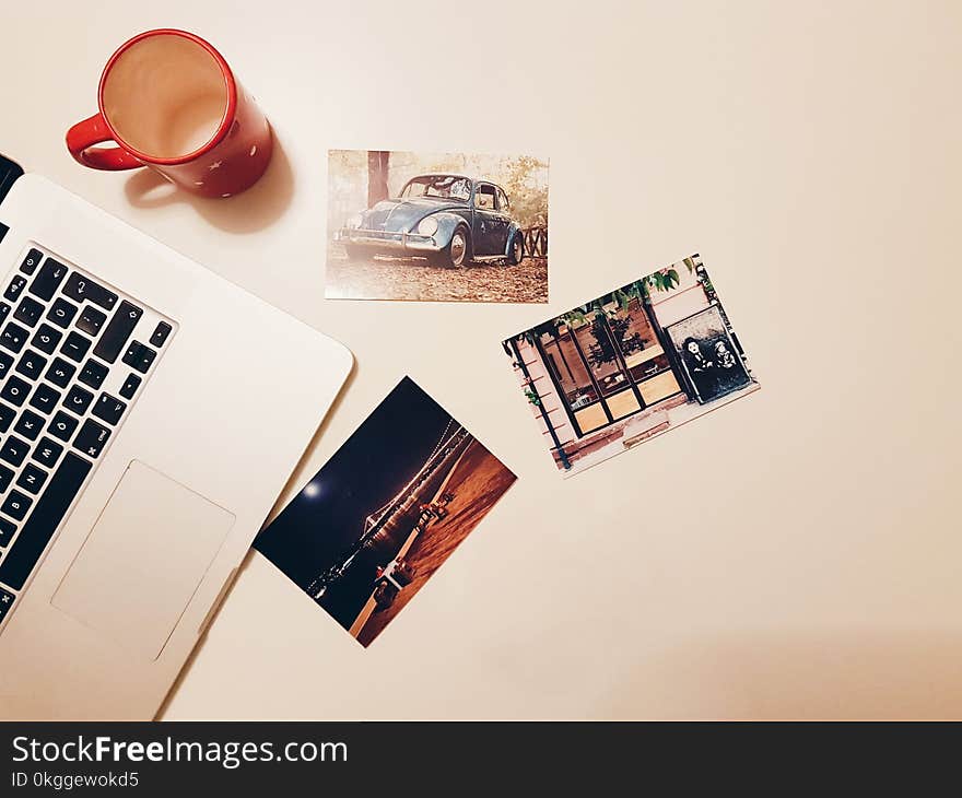 Three Assorted Photos on Desk Beside Laptop and Mug