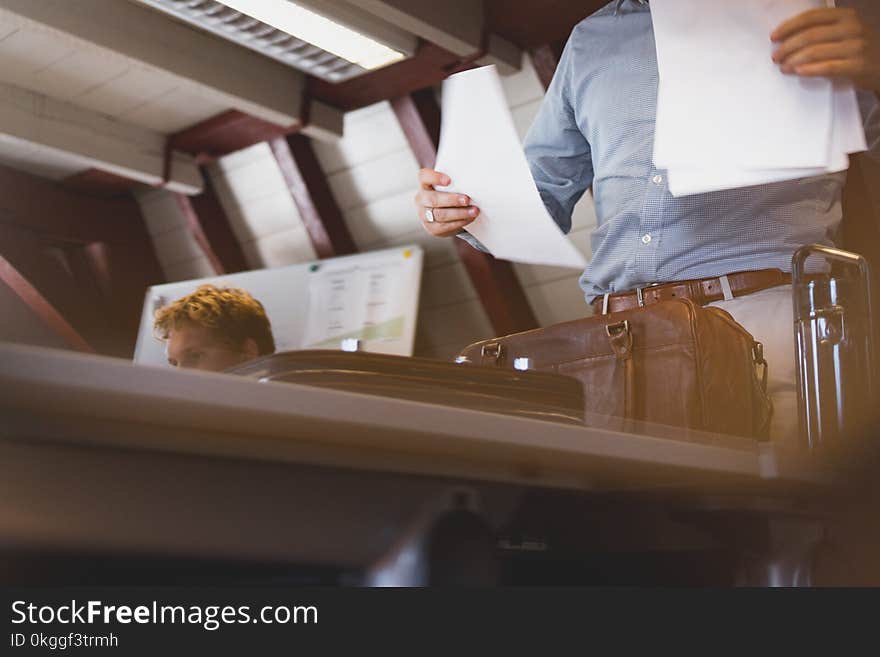 Man Wearing Blue Button-up Dress Shirt Holding White Printer Papers