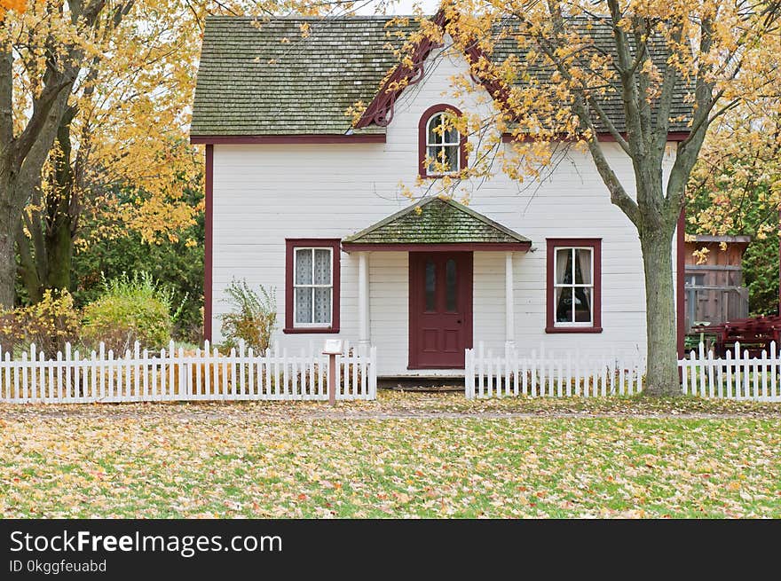 White and Red Wooden House With Fence