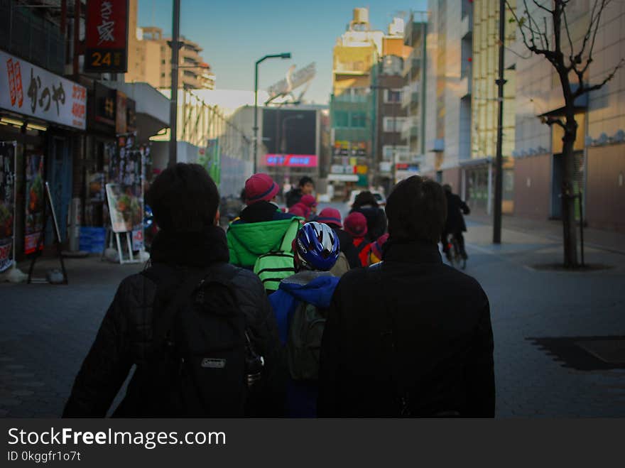 Photo of People Walking on Street Between Buildings