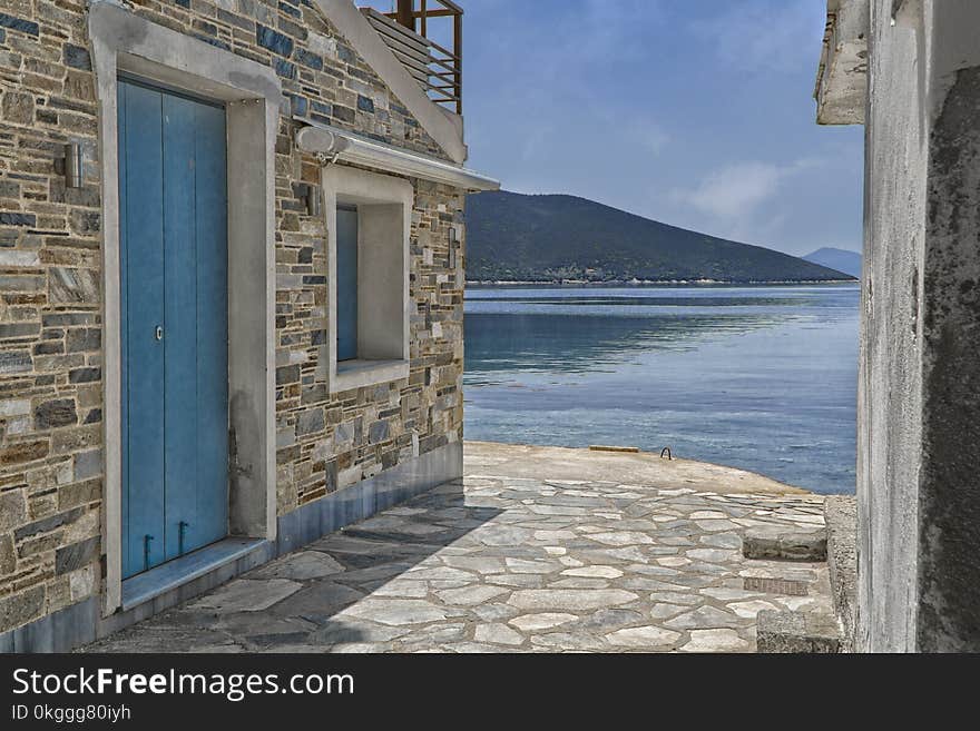 Gray Concrete Houses Near Body of Water