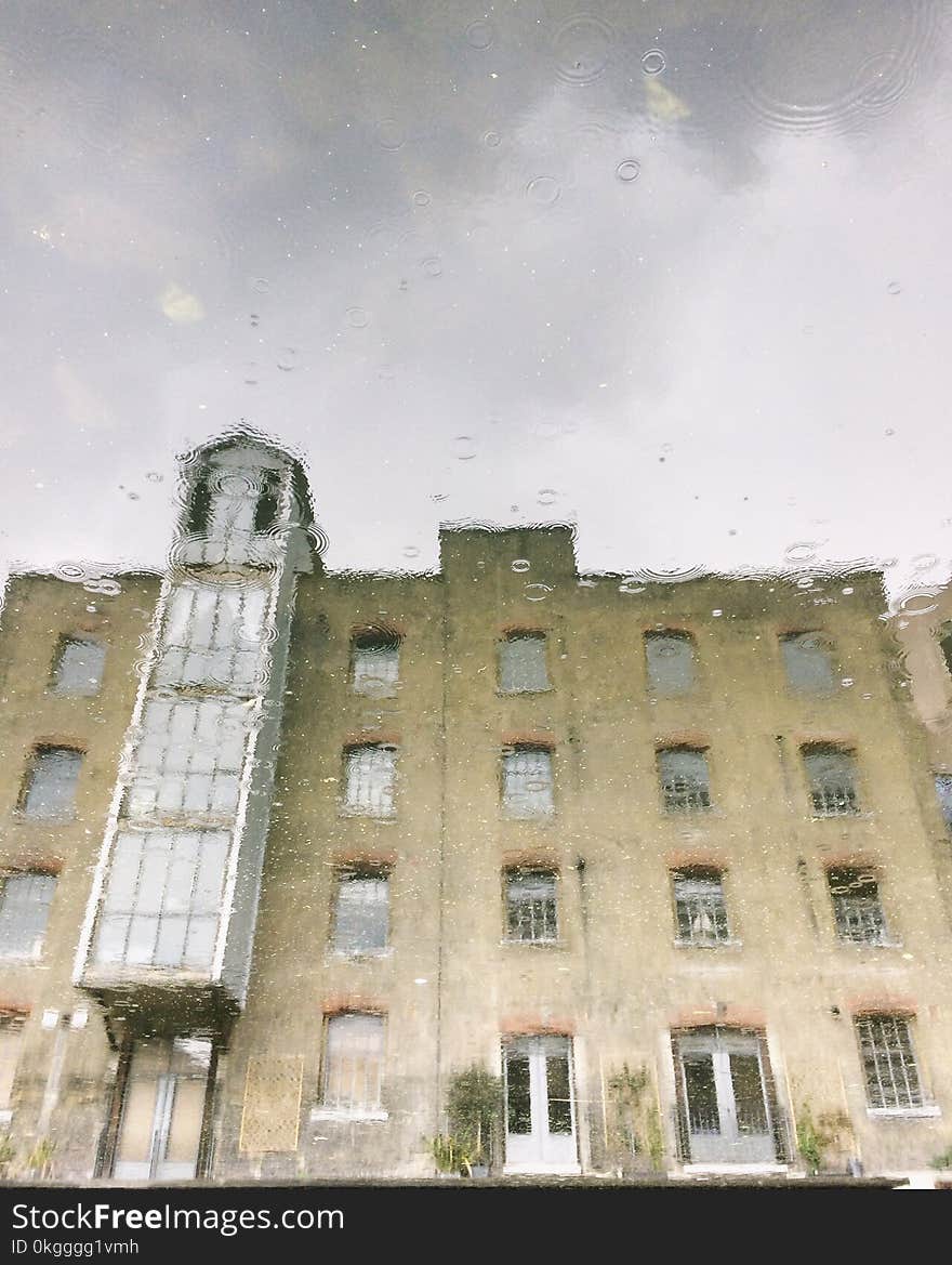 Brown and Gray Building Water Reflection