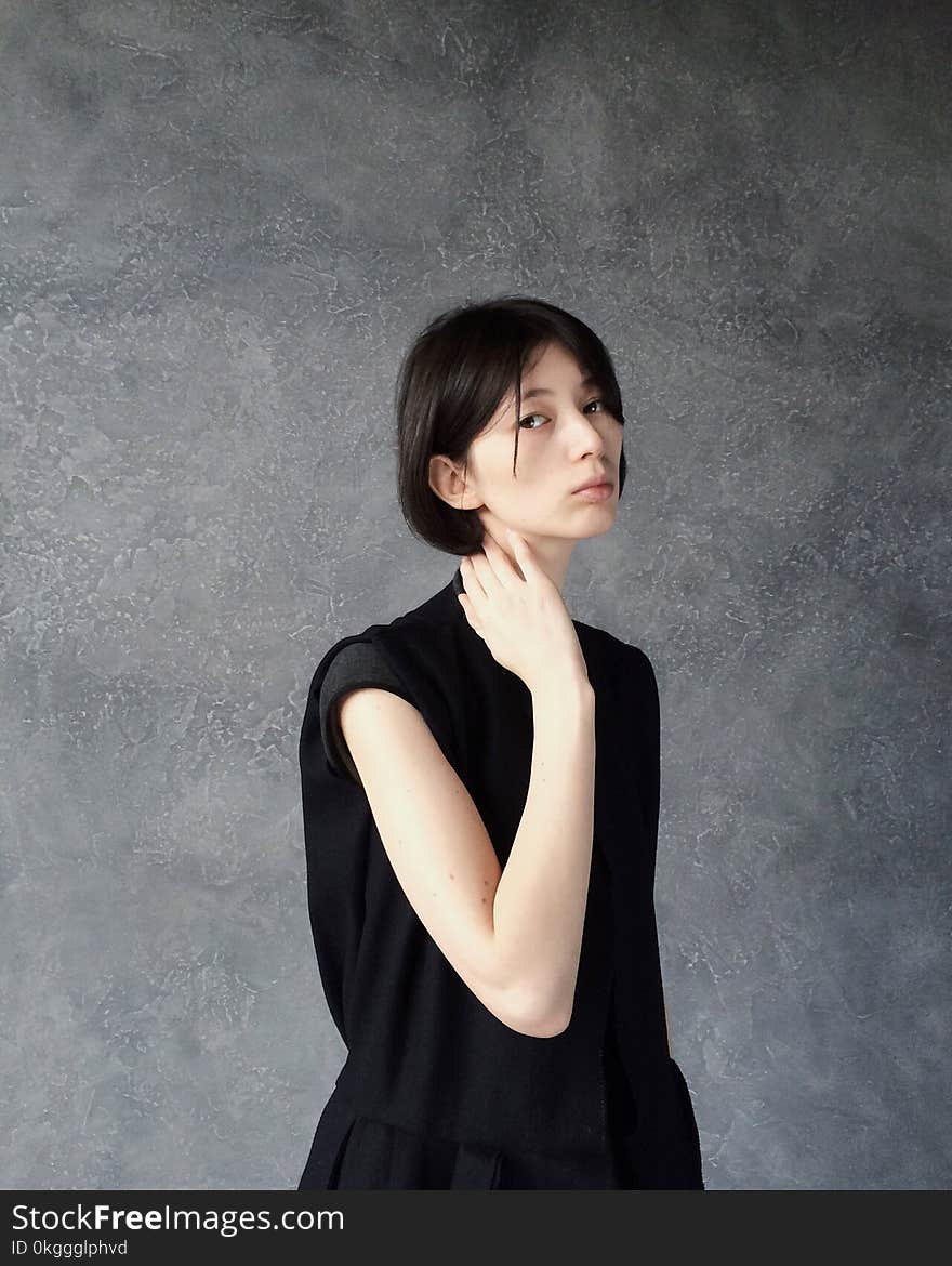 Woman in Black Top Standing Near Gray Wall