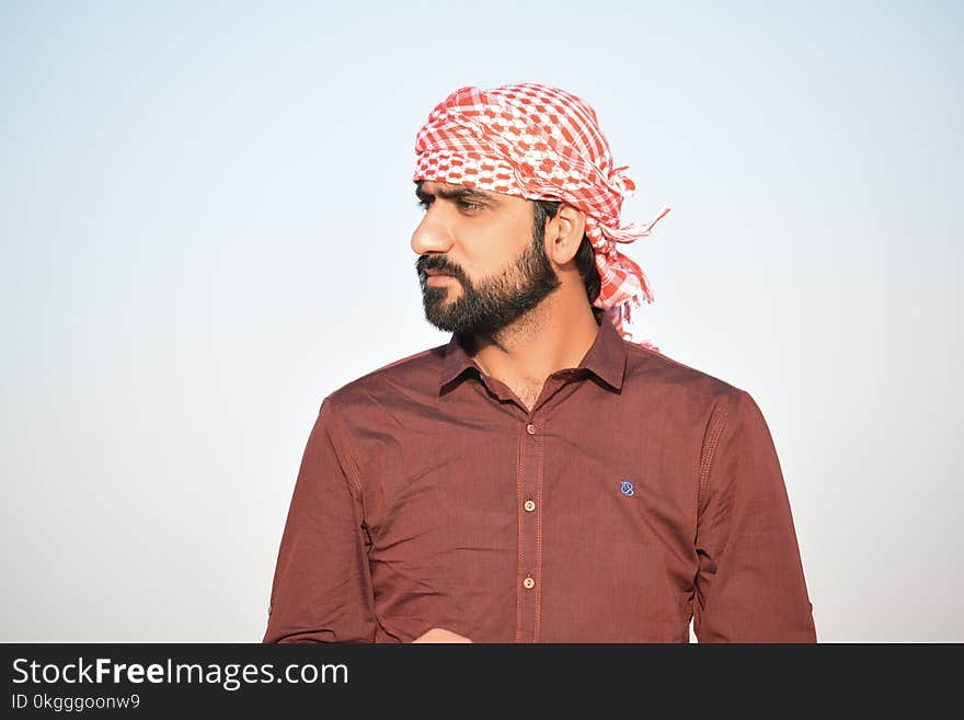 Portrait Photo of Man in Red Button-up Shirt and Red-and-white Headscarf