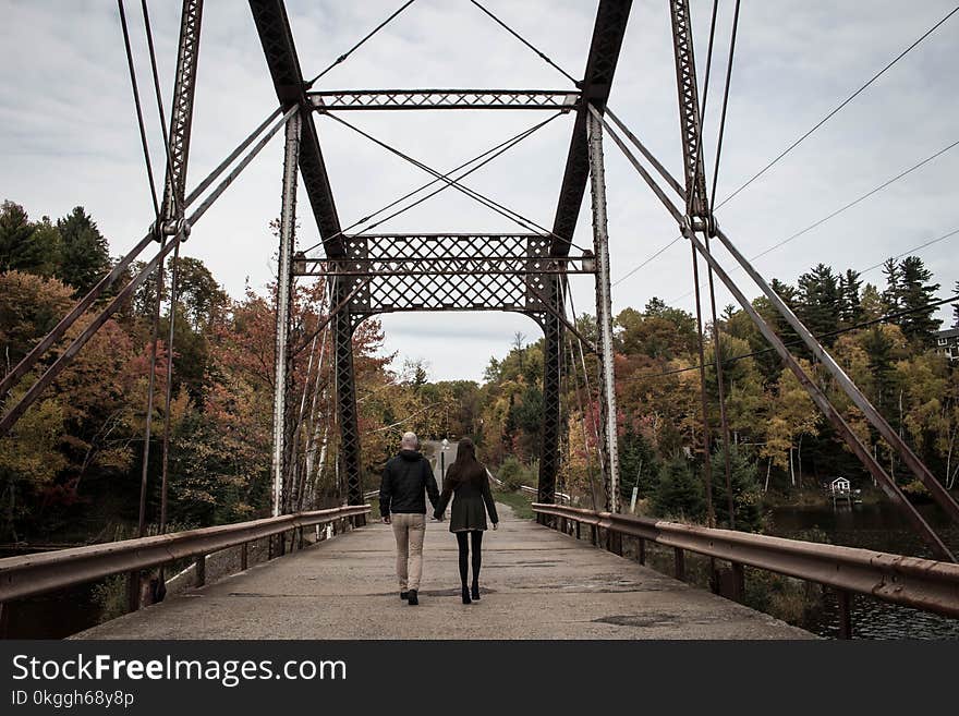 Couple Walking on Gray Bridge at Daytime