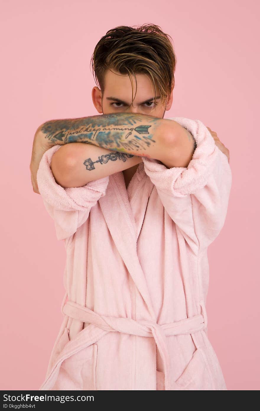 Man Wearing White Bathrobe Stands Near Pink Wall