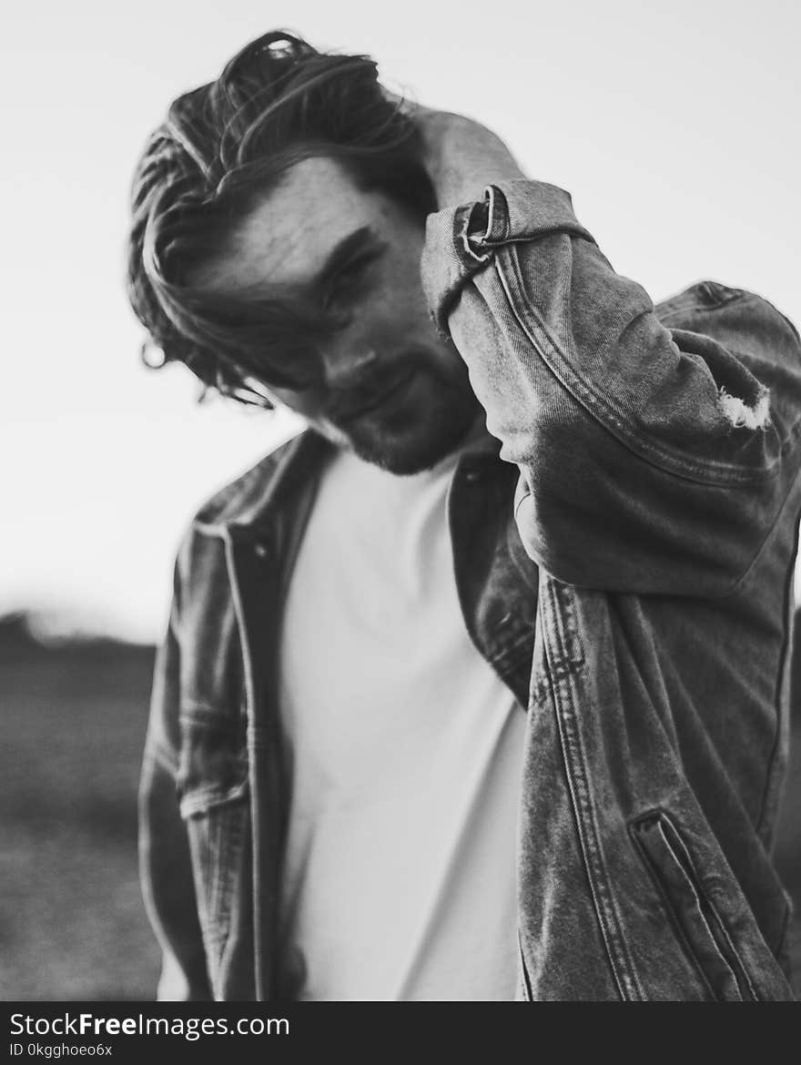 Grayscale Photo of Man Wearing Denim Jacket