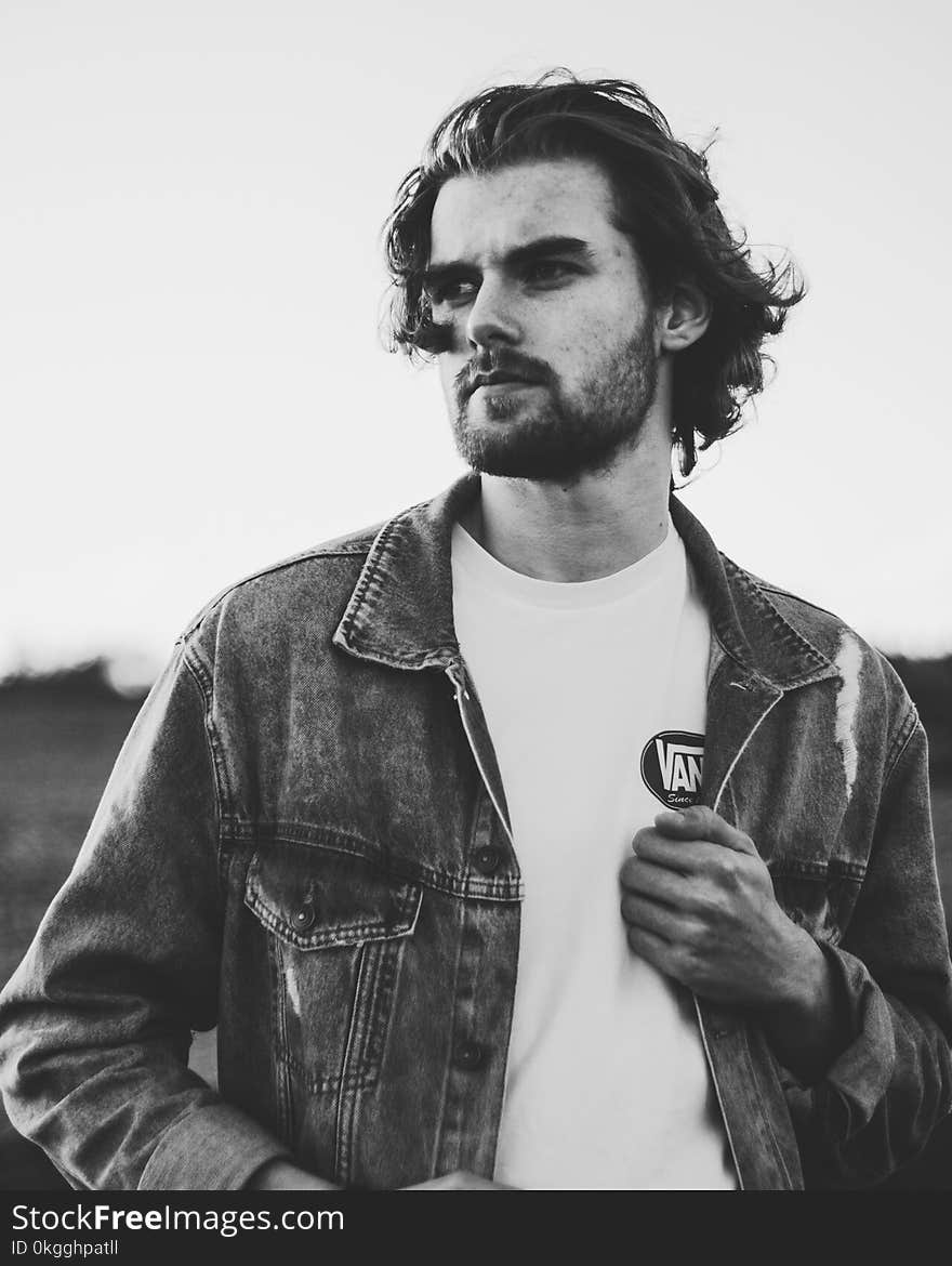 Grayscale Photo of Man Wearing Denim Jacket