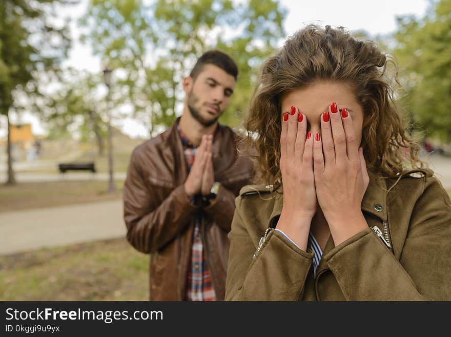 Woman With Green Jacket Behind Man With Brown Leather Jacket at Daytime