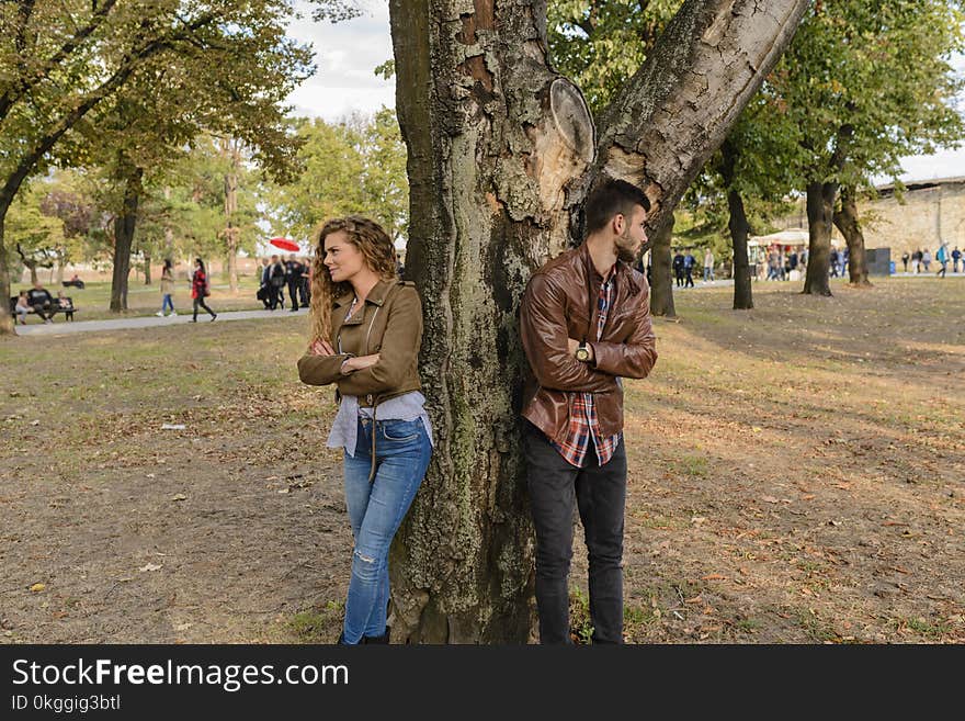 Man and Woman Wearing Leather Jackets Standing Under Tree