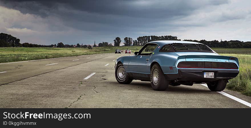 Blue Coupe on Brown Concrete Road