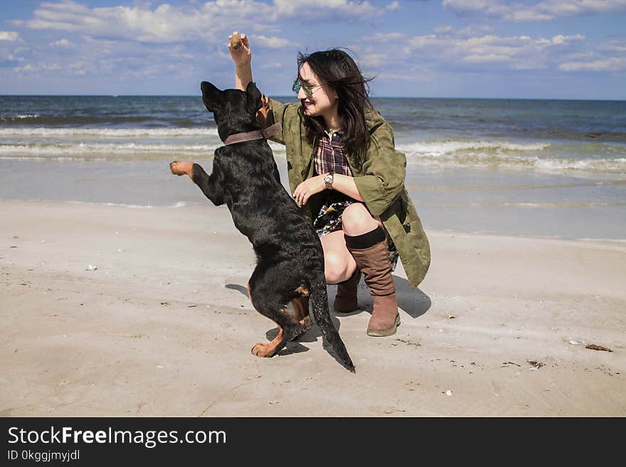 Woman Wearing Gray Coat Beside Black Dog