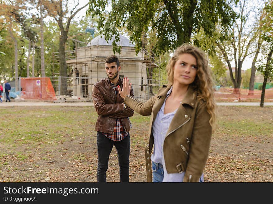 Man and Woman in Brown Leather Coat Standing on Brown Soil