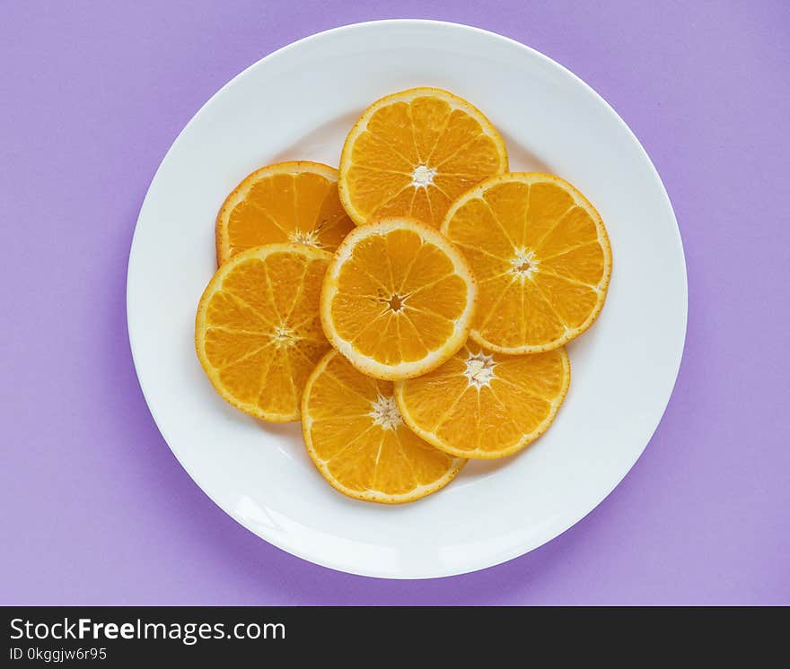 Sliced Orange Fruits on Round White Ceramic Plate