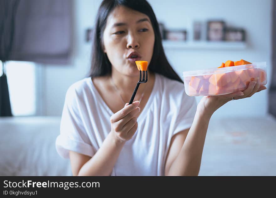 Young asian woman eating fresh fruits papaya slices after wake up,Concept healthy food. Young asian woman eating fresh fruits papaya slices after wake up,Concept healthy food