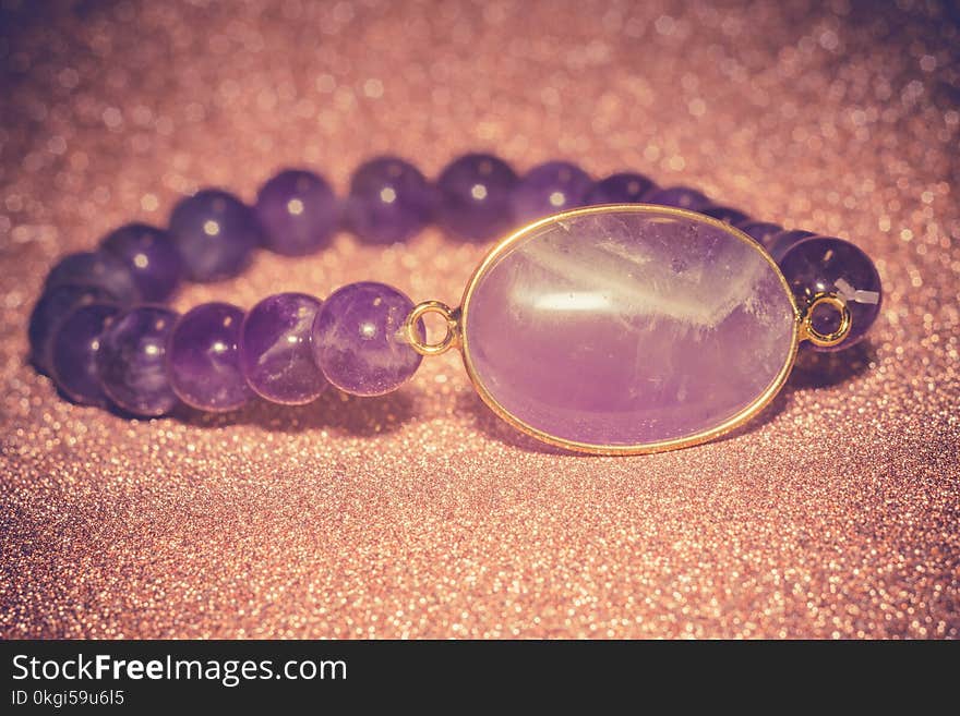 Fashion bracelet made of natural purple amethyst beads, filtered background. Fashion bracelet made of natural purple amethyst beads, filtered background.