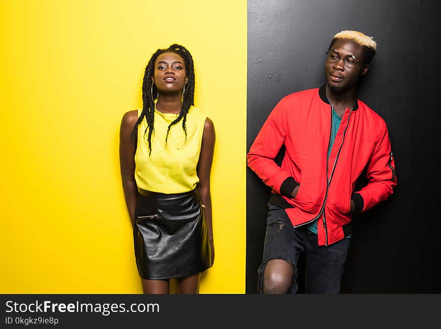 Young and happy afro american couple isolated on color background. Man and woman afro american have fun isolated on yellow and bla