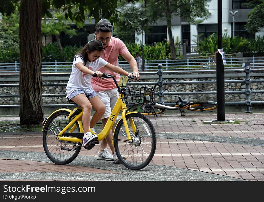 Photography of Girl Riding Bike Beside Man