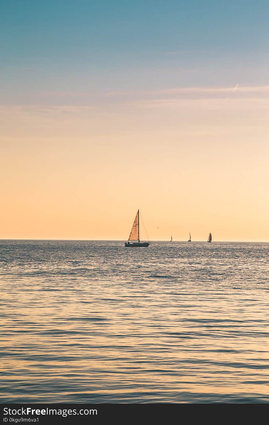 Beige Sailboat Under Clear Skies