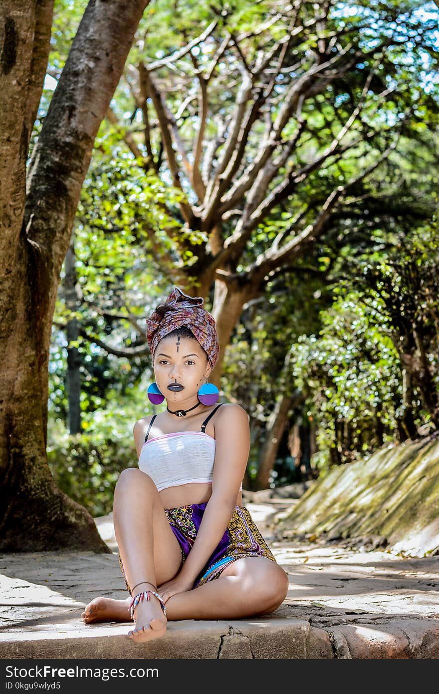 Woman Wearing White Crop Top Sitting on Concrete Floor Near Tree