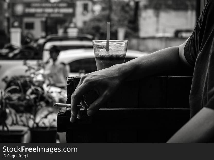 Grayscale Photo of Person Resting His Arm